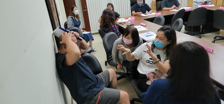  學員們圍坐在一起，神情投入地討論案例，現場呈現高度參與的學習能量。每組成員皆積極貢獻意見，氣氛熱絡，也能看到彼此合作與支持的過程。